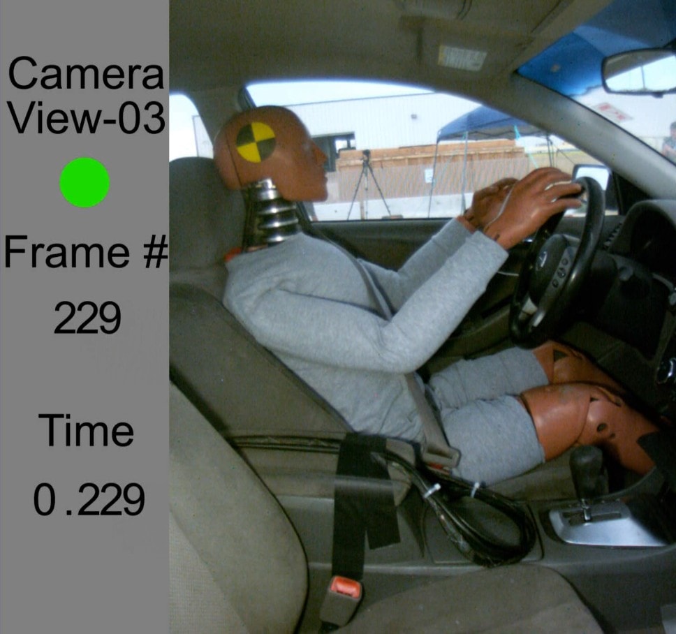 Crash test dummy in vehicle during rear-end collision test, Camera View-03 Frame 229